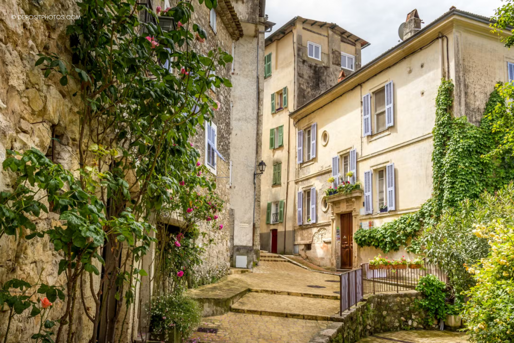 Ruelle pavée et façades fleuries dans le village de Gilette, arrière-pays de la Côte d’Azur